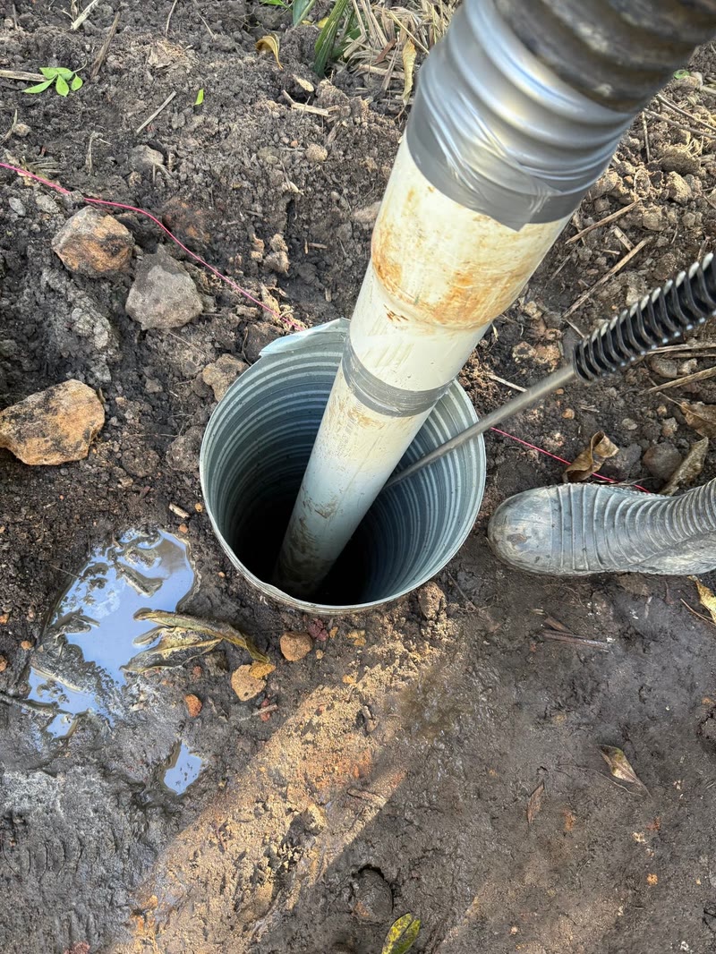 Vacuum hose positioned in a small service pit