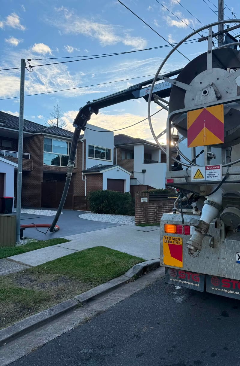 Vacuum truck and boom set up on a residential street