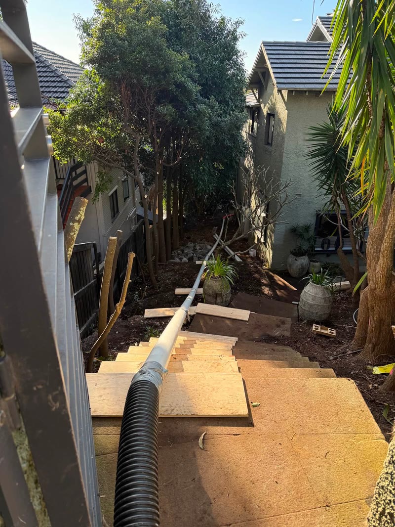 Vacuum hose routed through a narrow residential side passage