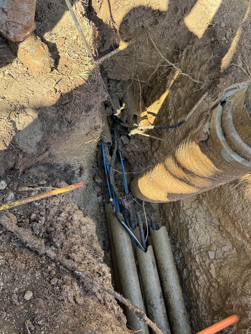 Excavated service conduits beside a building