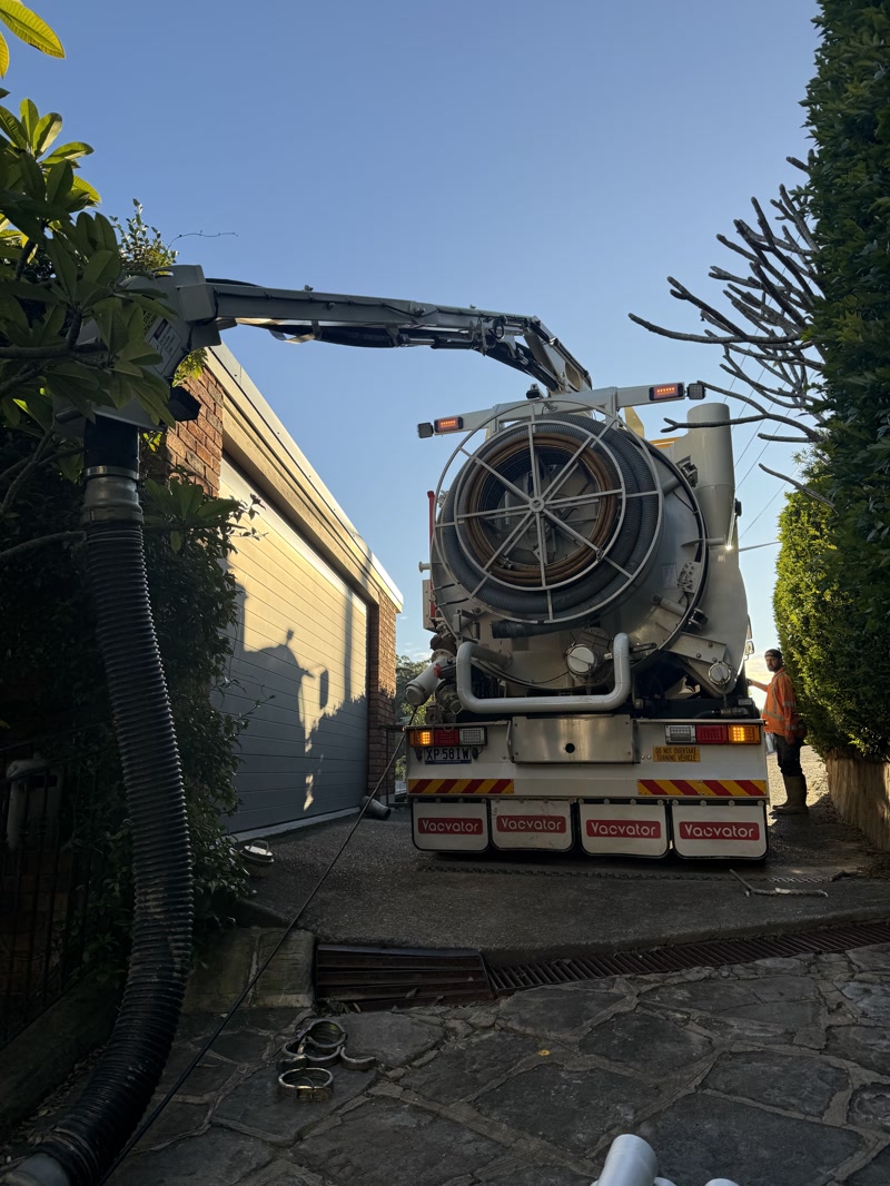 Large vacuum truck positioned in a narrow access lane