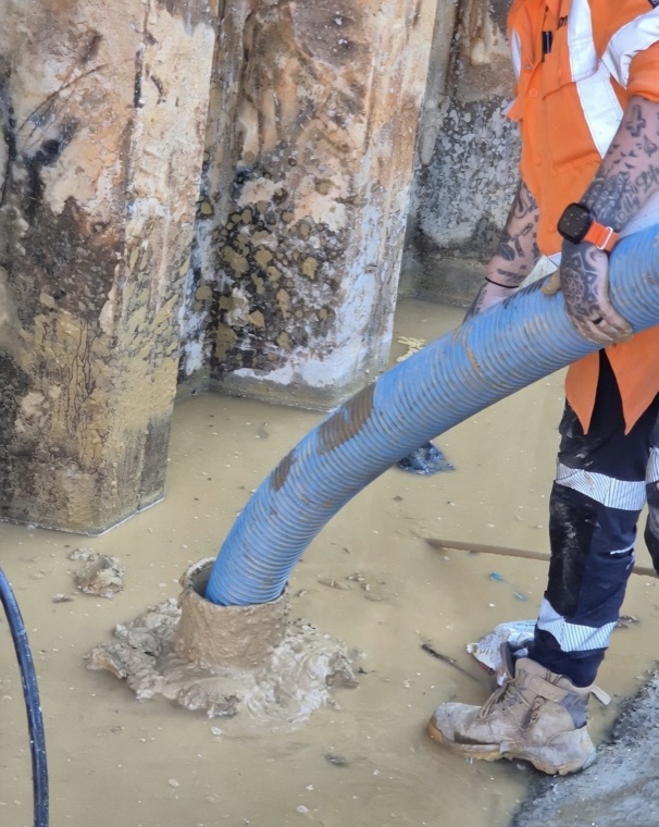 Hydro excavation worker with suction hose exposed services Sydney