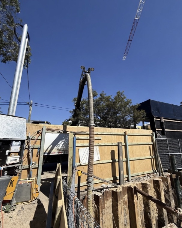 Vac truck boom extended over fence construction site Sydney