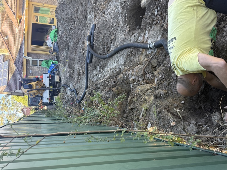 Operator in pit with vac hose during hydro excavation tight access Sydney